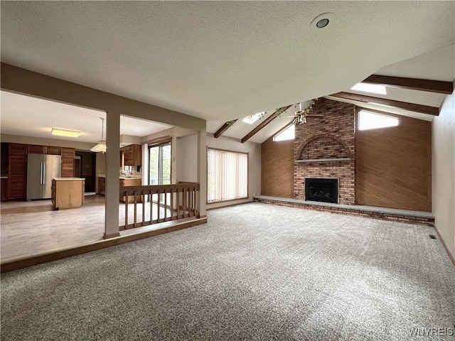 40 River Oaks Dr, Grand Island, NY 14072 - unfurnished living room featuring a brick fireplace, light carpet, a textured ceiling, and a skylight