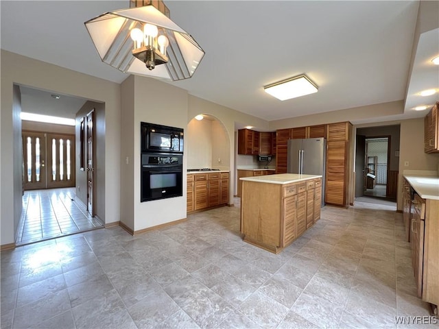 40 River Oaks Dr, Grand Island, NY 14072 - kitchen with black appliances, light countertops, brown cabinetry, a center island, and baseboards