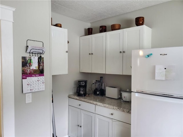 575 Lyon St, Elmira-City, NY 14904 - kitchen featuring freestanding refrigerator and white cabinets