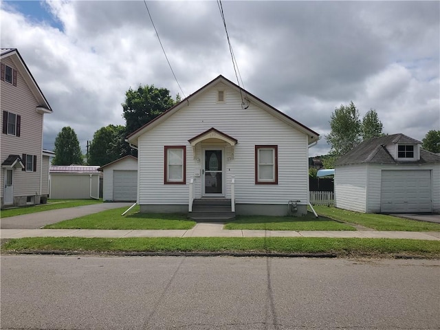 575 Lyon St, Elmira-City, NY 14904 - bungalow-style home with an outbuilding, a detached garage, and a front lawn