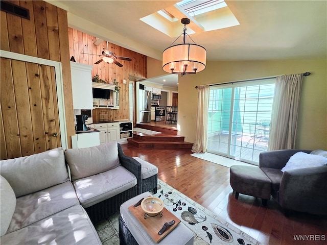 3666 S Hill Rd, Hamburg, NY 14075 - living room featuring a skylight, wood finished floors, wooden walls, a chandelier, and lofted ceiling