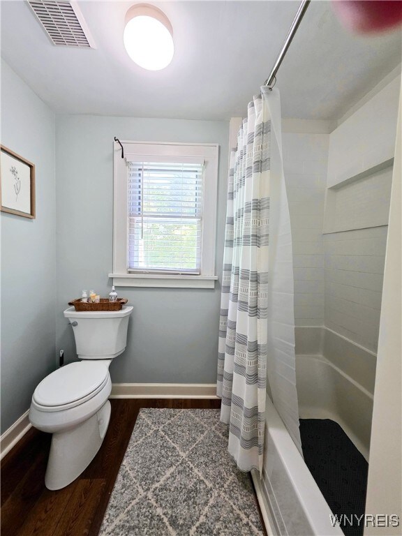3666 S Hill Rd, Hamburg, NY 14075 - bathroom featuring wood finished floors, toilet, shower / bath combo, and baseboards