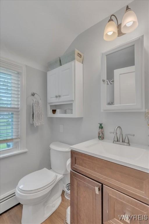 224 Dalton Dr, Tonawanda-Town, NY 14223 - bathroom with baseboard heating, vanity, toilet, and wood finished floors