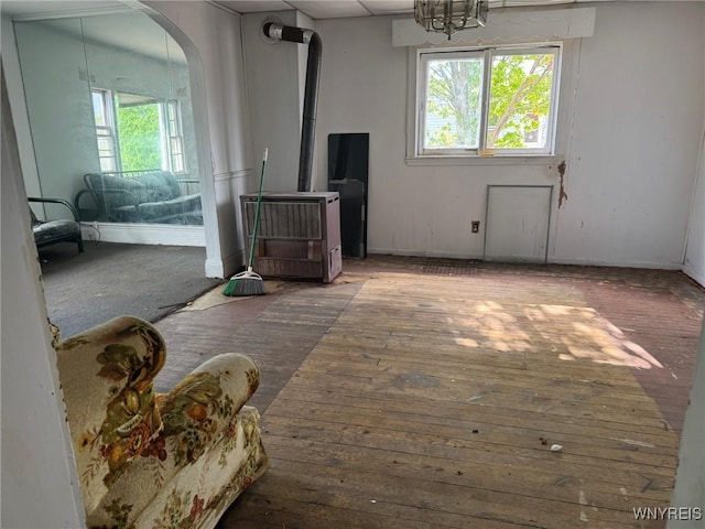 1306 E Lovejoy St, Buffalo, NY 14206 - living room featuring a wood stove, arched walkways, hardwood / wood-style floors, baseboards, and a chandelier