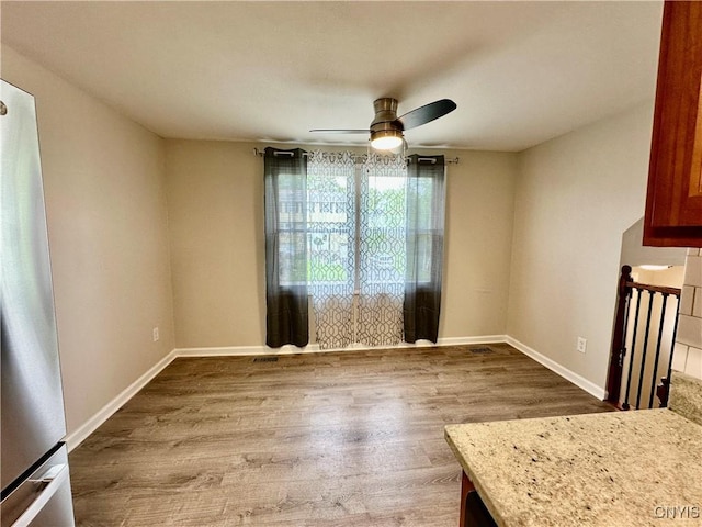 8408A Shallowcreek Rd, Clay, NY 13090 - unfurnished dining area with wood finished floors, ceiling fan, and baseboards
