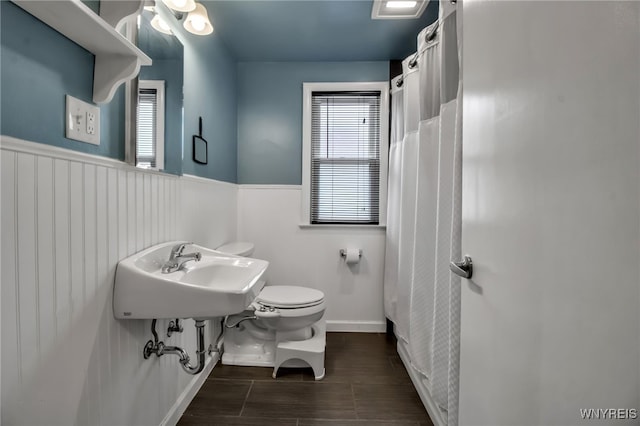 202 Tremaine Ave, Tonawanda-Town, NY 14217 - bathroom featuring toilet, a sink, a wainscoted wall, wood tiled floors, and a shower with curtain