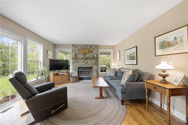 8105 Wilbarham Run, Pompey, NY 13104 - living room with light wood finished floors, plenty of natural light, a fireplace, and baseboards