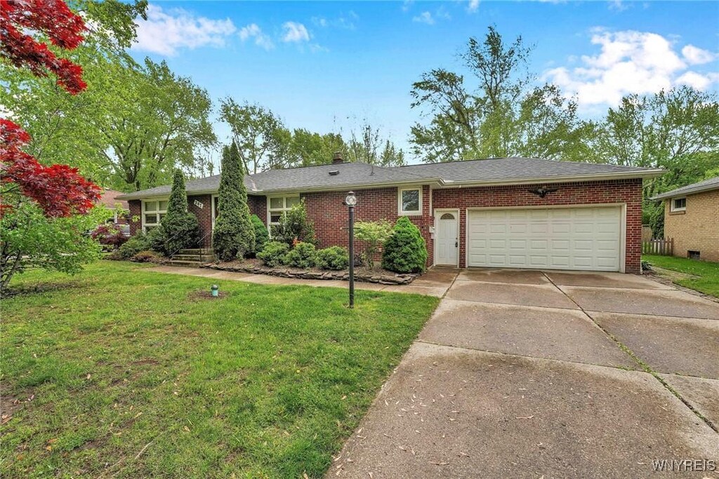 207 Siegfried Dr, Amherst, NY 14221 - single story home featuring concrete driveway, a garage, brick siding, and a front yard