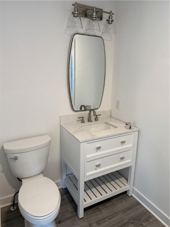 6731 County Road 12th Rd, South Bristol, NY 14512 - bathroom with vanity, toilet, wood finished floors, and baseboards