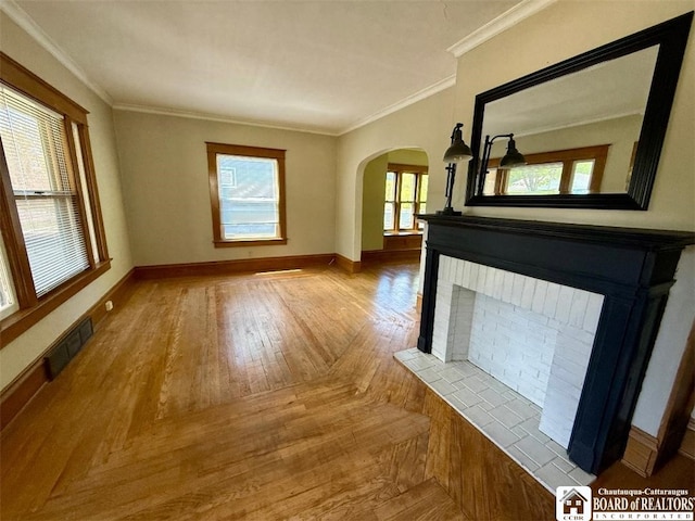 21 Juliet St, Jamestown, NY 14701 - unfurnished living room featuring arched walkways, a brick fireplace, baseboards, wood finished floors, and ornamental molding
