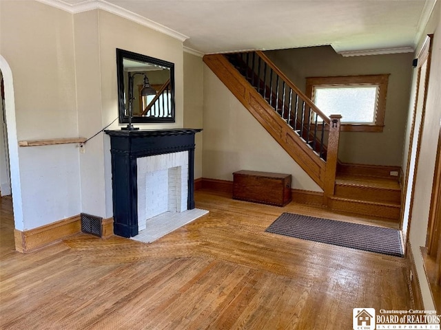 21 Juliet St, Jamestown, NY 14701 - stairs featuring baseboards, a brick fireplace, crown molding, wood finished floors, and arched walkways