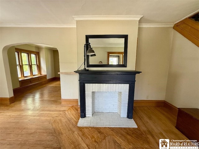 21 Juliet St, Jamestown, NY 14701 - unfurnished living room featuring baseboards, ornamental molding, a brick fireplace, wood finished floors, and arched walkways