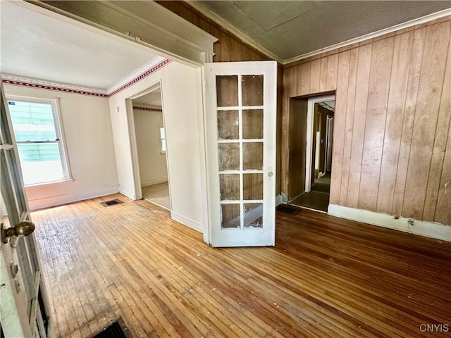 3628 S Salina St, Syracuse, NY 13205 - spare room featuring hardwood / wood-style floors, wooden walls, baseboards, and ornamental molding