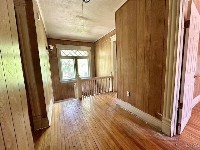 3628 S Salina St, Syracuse, NY 13205 - hallway featuring hardwood / wood-style flooring, an upstairs landing, wood walls, baseboards, and a textured ceiling