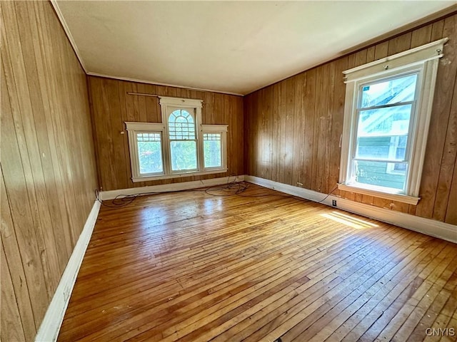 3628 S Salina St, Syracuse, NY 13205 - empty room featuring wood-type flooring, wood walls, and baseboards