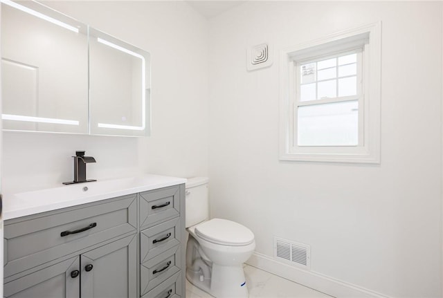 636 Ridge Rd, Webster, NY 14580 - bathroom featuring toilet, baseboards, vanity, and marble look tile flooring