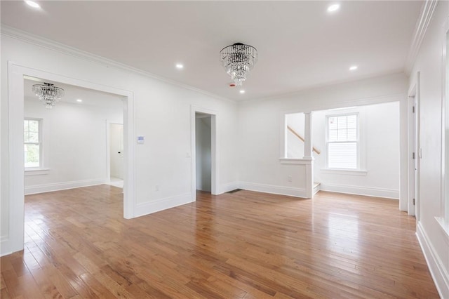 636 Ridge Rd, Webster, NY 14580 - empty room with a chandelier, stairway, crown molding, light wood-type flooring, and baseboards