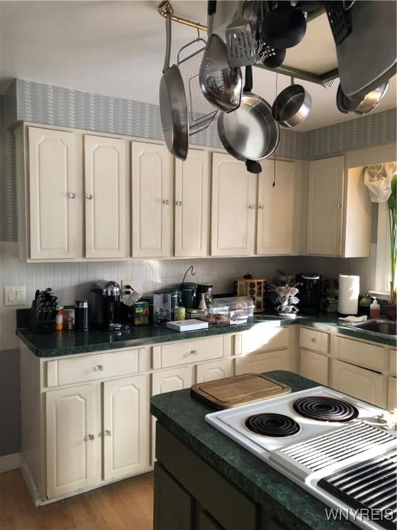 148 Marlin Rd, Grand Island, NY 14072 - kitchen with dark countertops, light wood-type flooring, white cabinets, white cooktop, and range