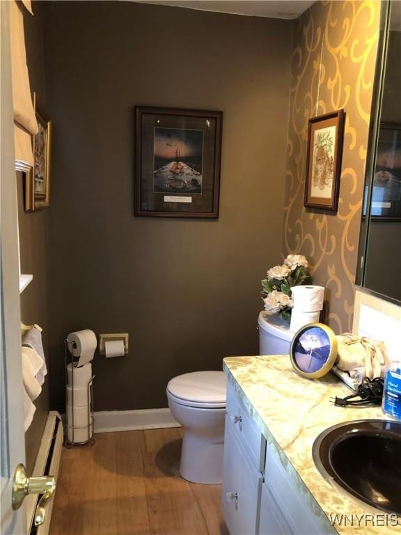 148 Marlin Rd, Grand Island, NY 14072 - bathroom featuring wood finished floors, toilet, vanity, baseboard heating, and baseboards
