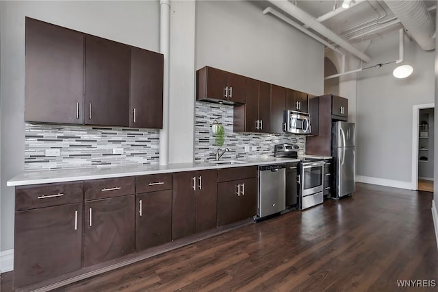 2917 Main St Unit 418, Buffalo, NY 14214 - kitchen with appliances with stainless steel finishes, a towering ceiling, a sink, light countertops, and dark brown cabinetry