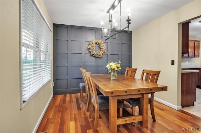 4343 Lockport Rd, Cambria, NY 14094 - dining room with a decorative wall, a chandelier, light wood-style floors, and baseboards