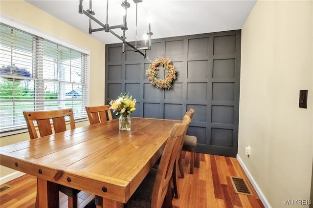 4343 Lockport Rd, Cambria, NY 14094 - dining room featuring a decorative wall, a chandelier, baseboards, and light wood-style flooring