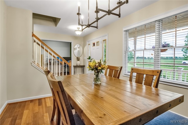 4343 Lockport Rd, Cambria, NY 14094 - dining space featuring wood finished floors, baseboards, a chandelier, and stairway