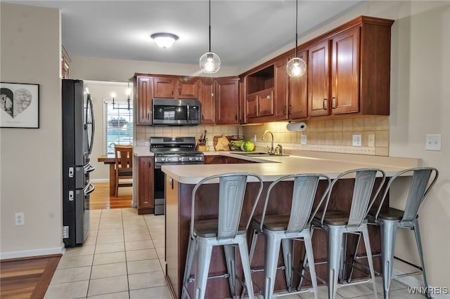 4343 Lockport Rd, Cambria, NY 14094 - kitchen with stainless steel appliances, a peninsula, backsplash, a kitchen breakfast bar, and baseboards