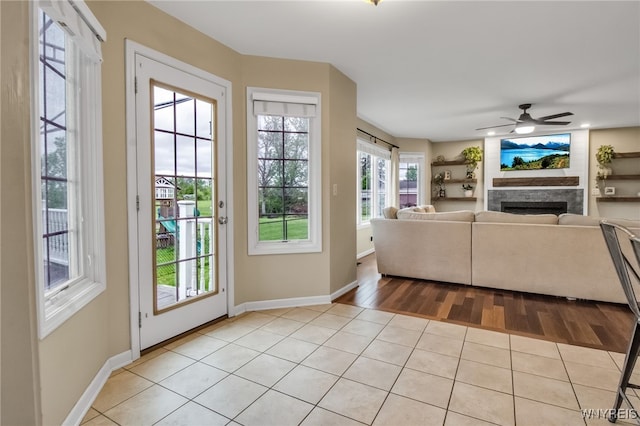 4343 Lockport Rd, Cambria, NY 14094 - living area featuring a fireplace, light wood finished floors, baseboards, and ceiling fan