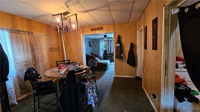 55 Lewis St, Buffalo, NY 14206 - carpeted dining space with wood walls, a chandelier, a ceiling fan, and baseboards