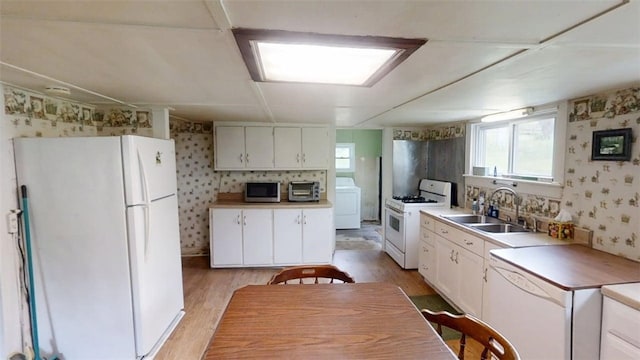 110 Furnace Hill Rd, Guilford, NY 13780 - kitchen with white appliances, washer / clothes dryer, wallpapered walls, a sink, and light wood-style floors
