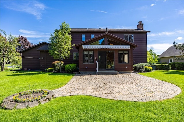 144 Guygrace Ln, Penfield, NY 14580 - back of property with a chimney, a yard, a patio area, and decorative driveway