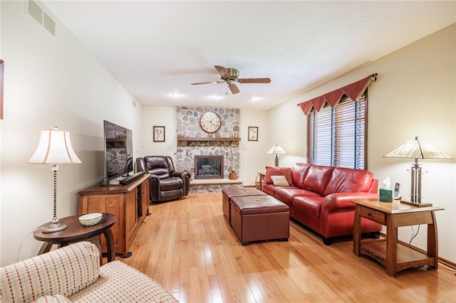 144 Guygrace Ln, Penfield, NY 14580 - living area featuring ceiling fan, light wood finished floors, and a stone fireplace