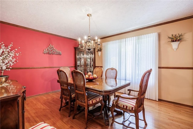144 Guygrace Ln, Penfield, NY 14580 - dining room featuring a chandelier, ornamental molding, light wood-style floors, and a textured ceiling