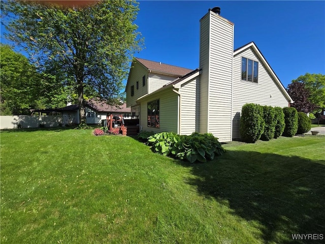 589 Briarwood Ln, Lewiston, NY 14092 - view of property exterior with a chimney, a lawn, and a deck