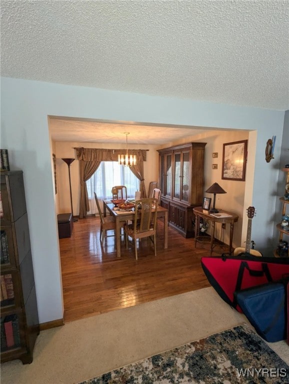 589 Briarwood Ln, Lewiston, NY 14092 - carpeted dining space with a chandelier, a textured ceiling, and wood finished floors
