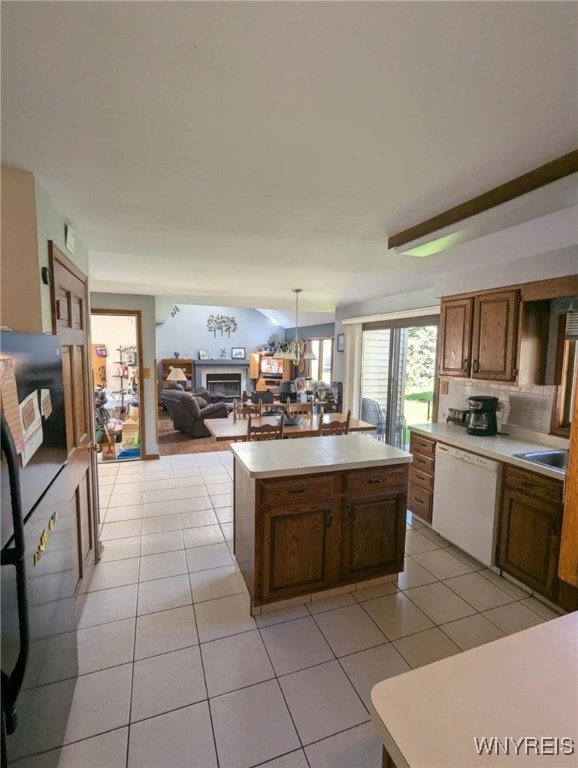 589 Briarwood Ln, Lewiston, NY 14092 - kitchen featuring dishwasher, a kitchen island, light countertops, light tile patterned floors, and a sink
