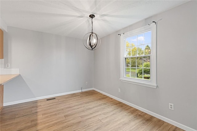 194 Citation Dr, Henrietta, NY 14467 - unfurnished dining area with light wood-style floors, a chandelier, and baseboards