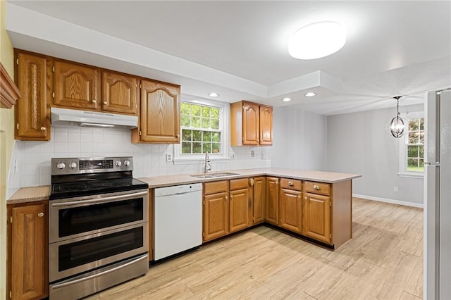 194 Citation Dr, Henrietta, NY 14467 - kitchen with white appliances, under cabinet range hood, a sink, a peninsula, and light countertops
