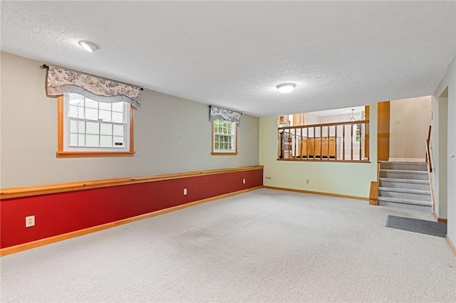 194 Citation Dr, Henrietta, NY 14467 - below grade area featuring a textured ceiling, carpet floors, baseboards, and stairs
