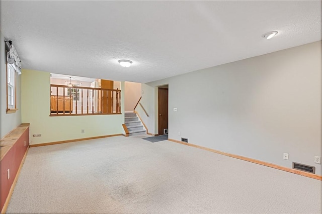 194 Citation Dr, Henrietta, NY 14467 - carpeted spare room featuring stairway, a textured ceiling, and baseboards