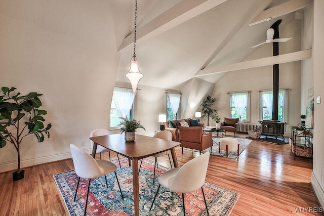 403 Elmwood Ave, Buffalo, NY 14222 - dining room with high vaulted ceiling, a wood stove, beamed ceiling, light wood-type flooring, and radiator