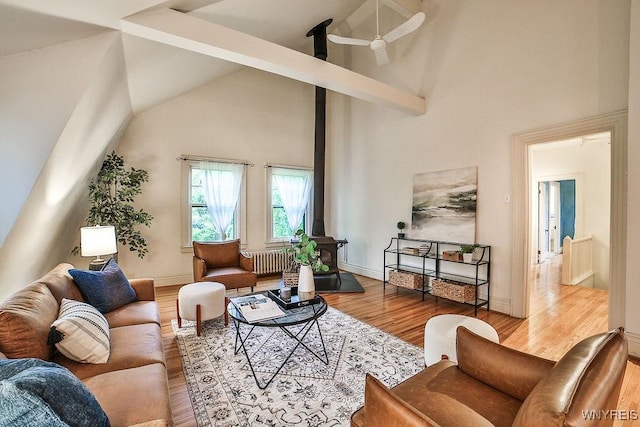 403 Elmwood Ave, Buffalo, NY 14222 - living room with high vaulted ceiling, radiator, wood finished floors, a wood stove, and baseboards