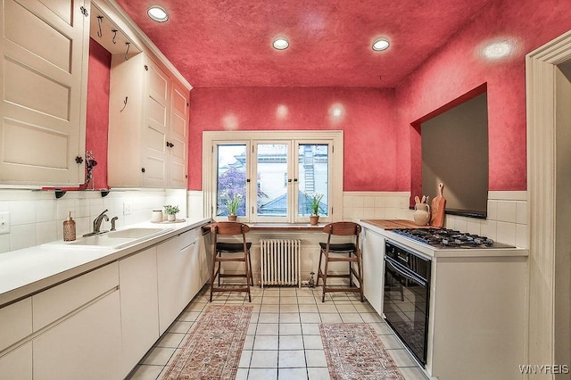 403 Elmwood Ave, Buffalo, NY 14222 - kitchen with radiator heating unit, oven, a sink, stainless steel gas stovetop, and recessed lighting