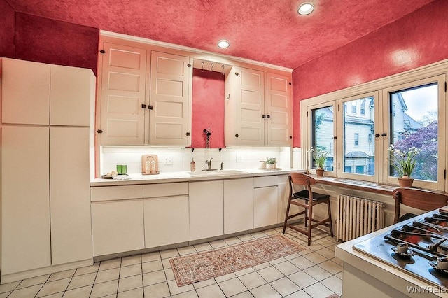 403 Elmwood Ave, Buffalo, NY 14222 - kitchen with radiator, a sink, light countertops, recessed lighting, and light tile patterned floors