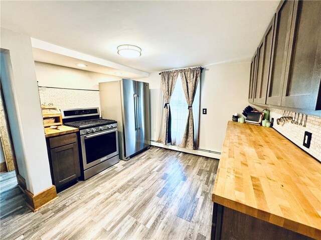 245 Owego St, Montour, NY 14865 - kitchen featuring wood counters, appliances with stainless steel finishes, decorative backsplash, and light wood-style floors