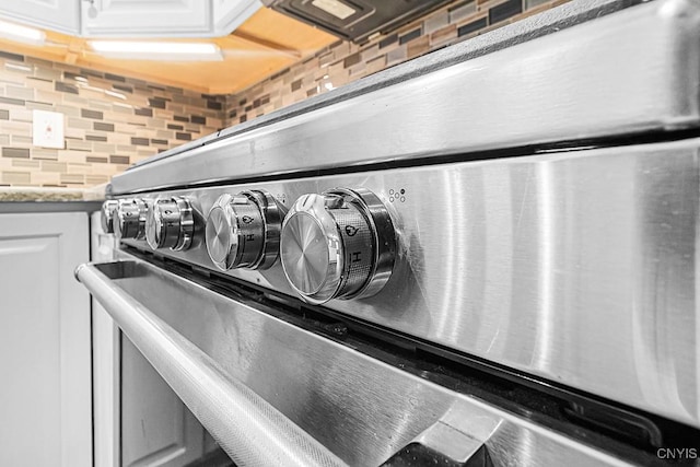 5 Glencrest Blvd, New Hartford, NY 13413 - detailed view of stainless steel range oven, decorative backsplash, white cabinets, and light stone counters