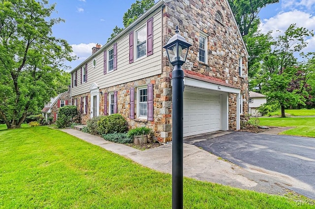 5 Glencrest Blvd, New Hartford, NY 13413 - view of property exterior with stone siding, a chimney, a lawn, a garage, and driveway