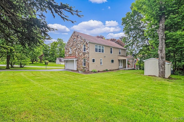 5 Glencrest Blvd, New Hartford, NY 13413 - back of property featuring an attached garage, driveway, a lawn, and stone siding