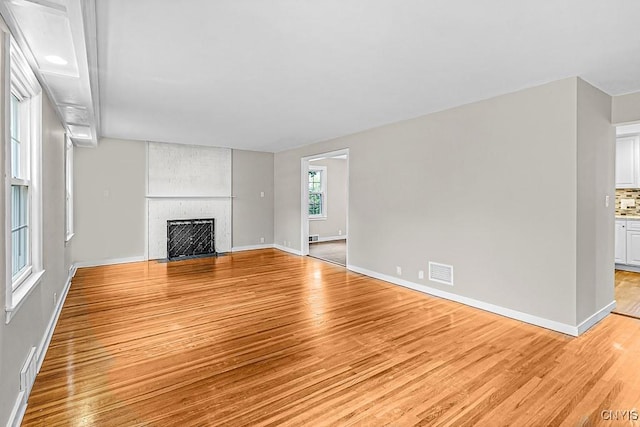 5 Glencrest Blvd, New Hartford, NY 13413 - unfurnished living room with light wood-style flooring, baseboards, and a large fireplace